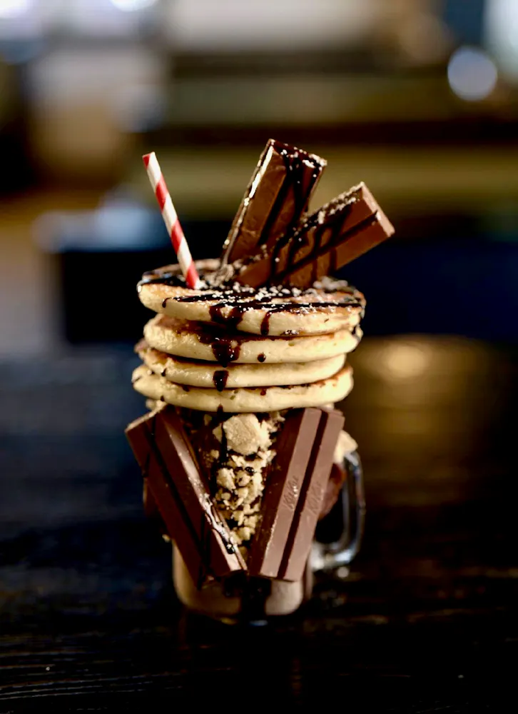 a glass with a milkshake with cookies and chocolate
