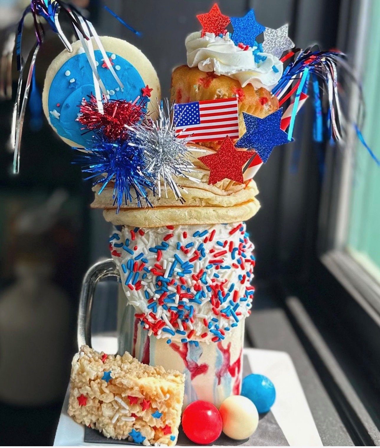 a glass cup with a cupcake and a bag on top
