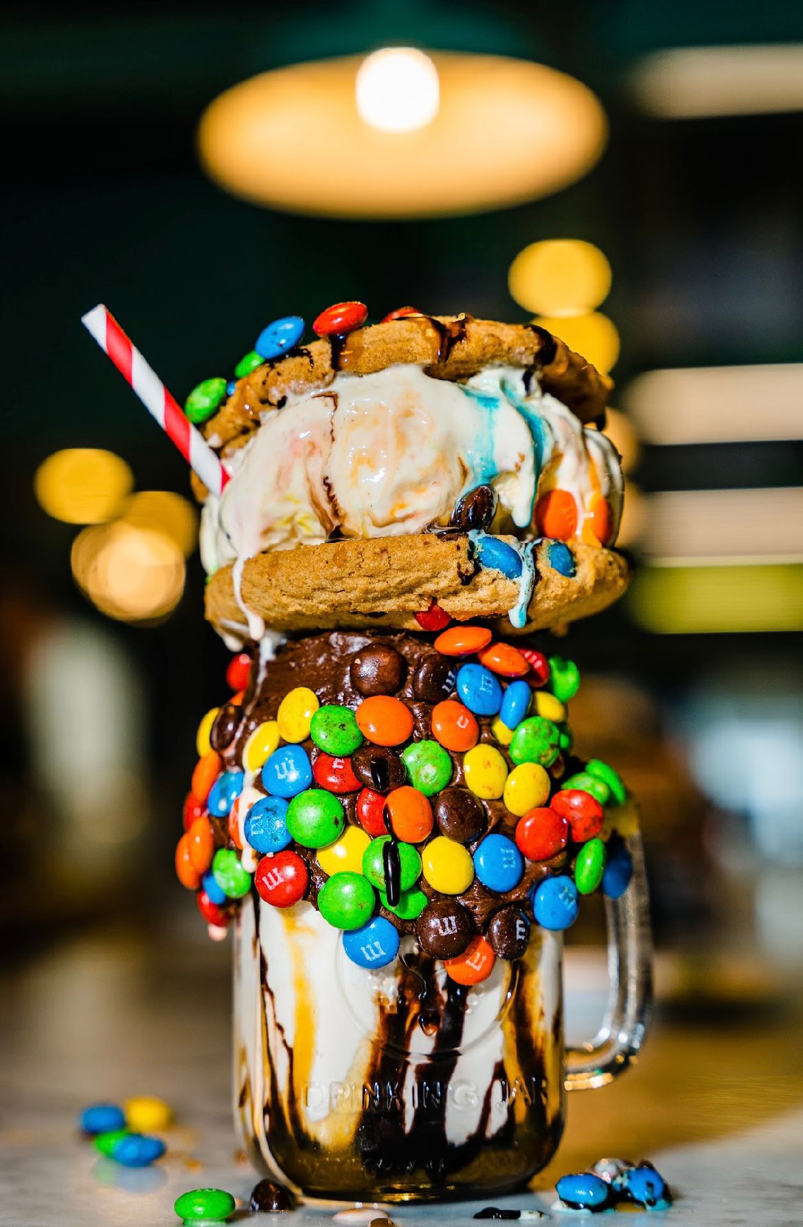 a large milkshake with a cookie and candy on top