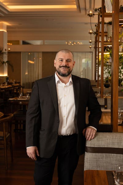 a man in a suit standing in front of a table