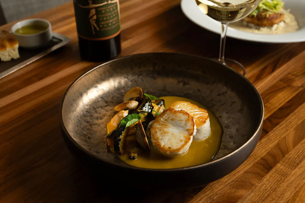 a bowl of food sitting on top of a wooden table