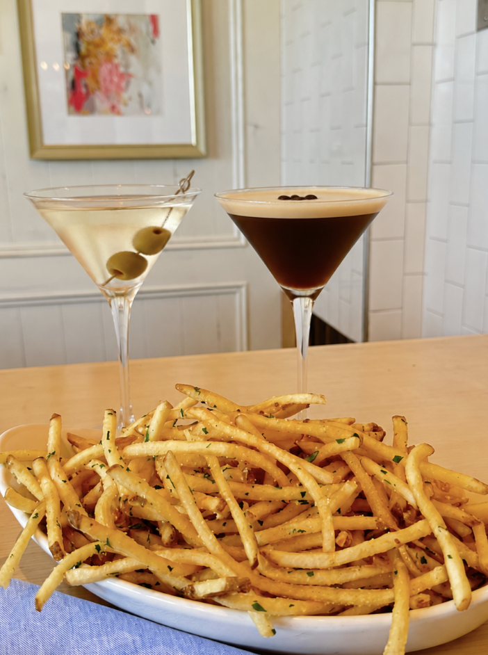 girl dinner in henderson featuring martinis, fries, pasta, and caesar salad 