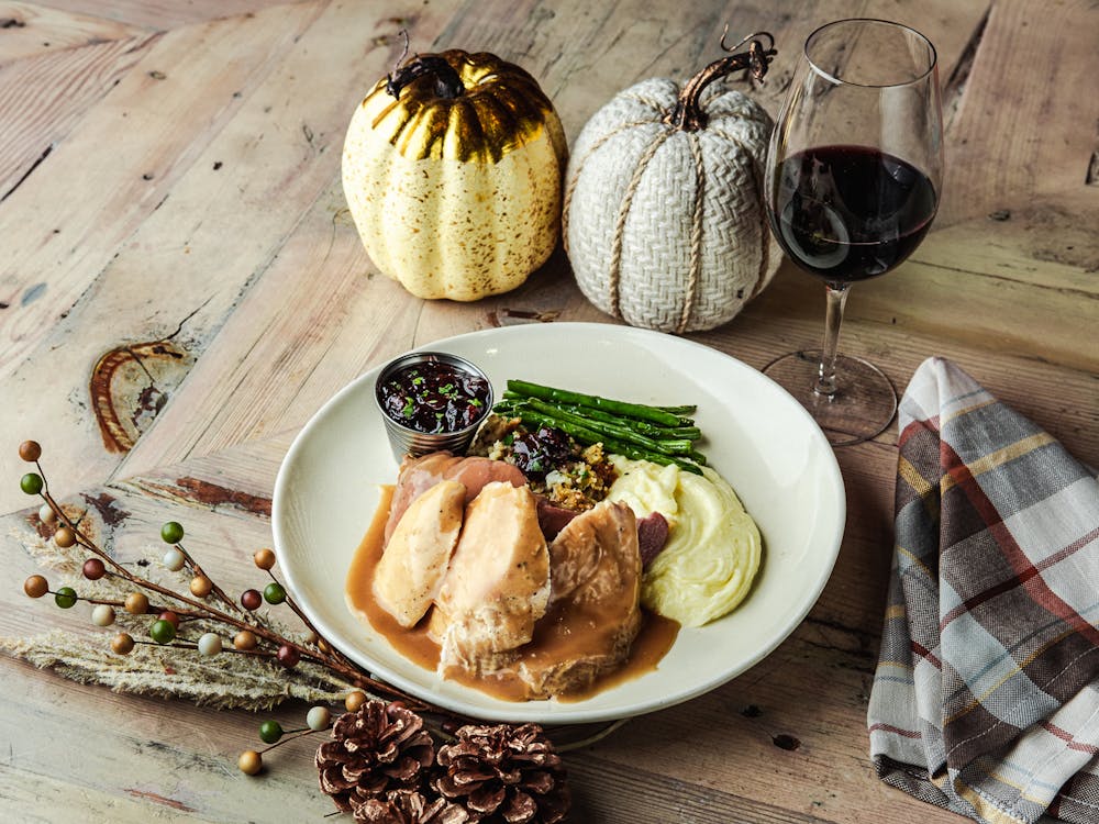 Thanksgiving platter with roasted turkey, mashed potatoes, stuffing, and cranberry sauce served on a rustic plate at this henderson italian restaurant