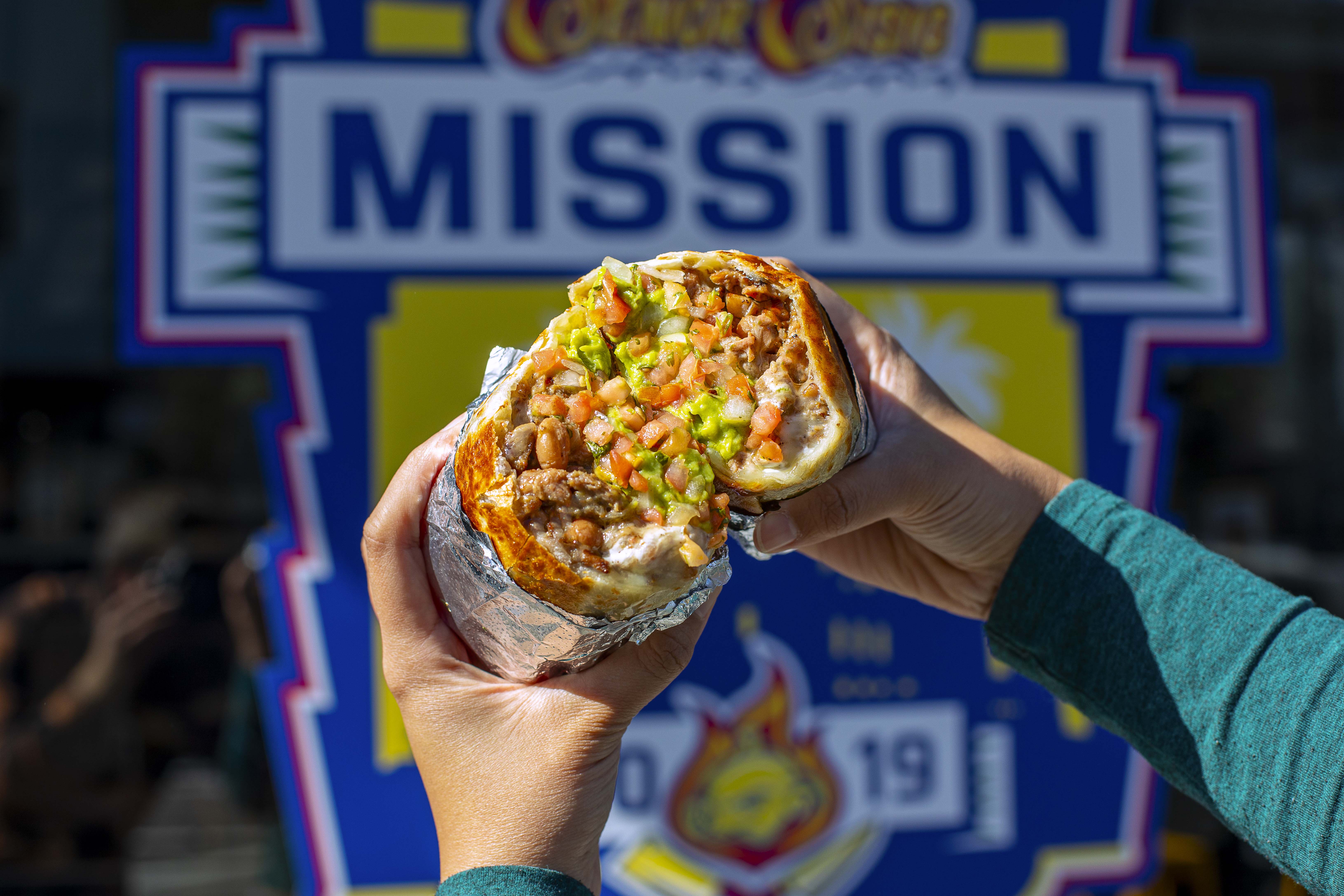 a hand holding a piece of pizza