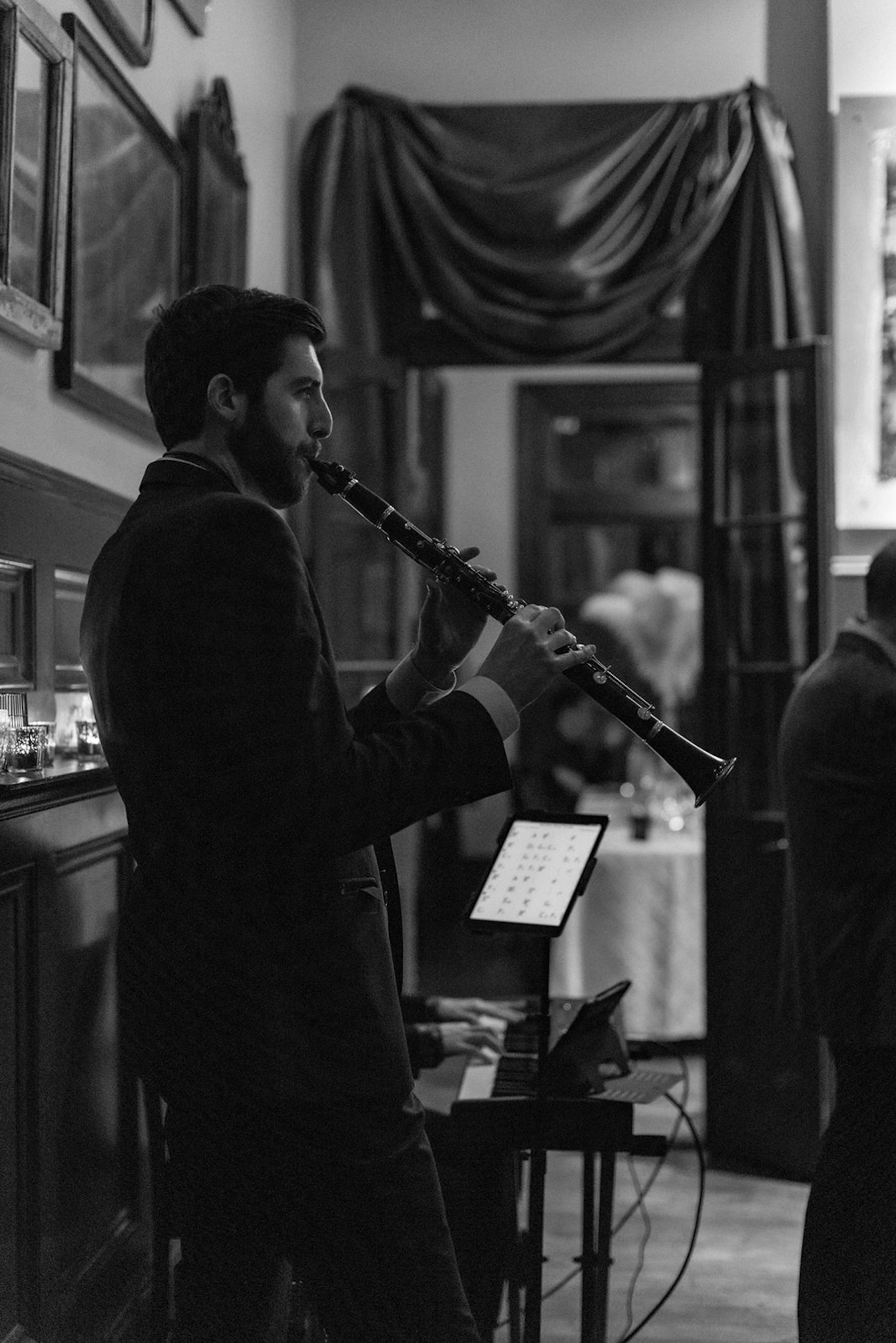 A black and white image of a man playing a flute