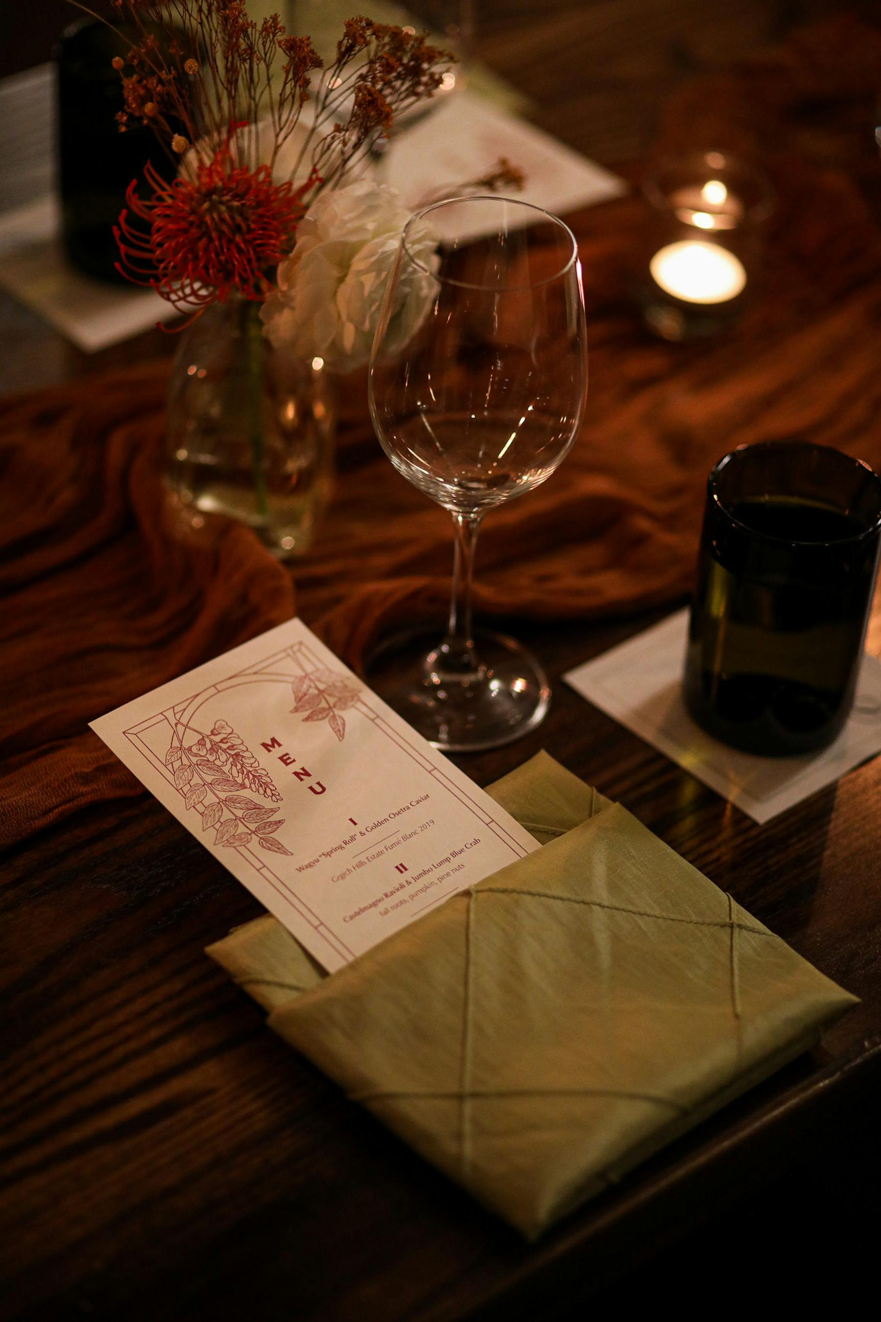 a glass of wine sitting on top of a wooden table