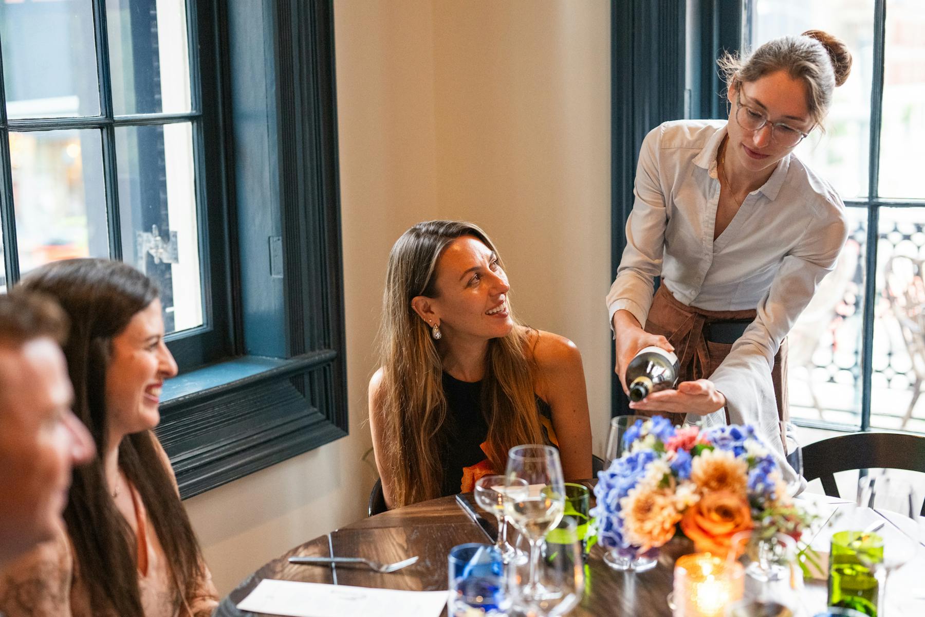 a group of people sitting at a table in front of a window