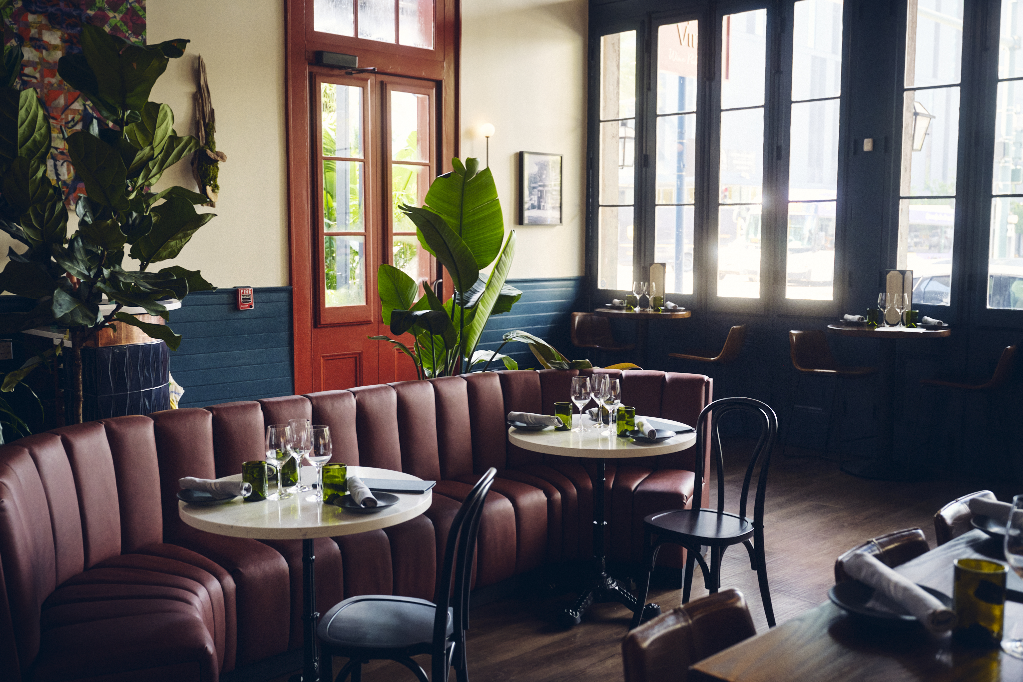 A warm restaurant atmosphere highlighted by a plush leather couch and chic chairs, creating a welcoming space for diners