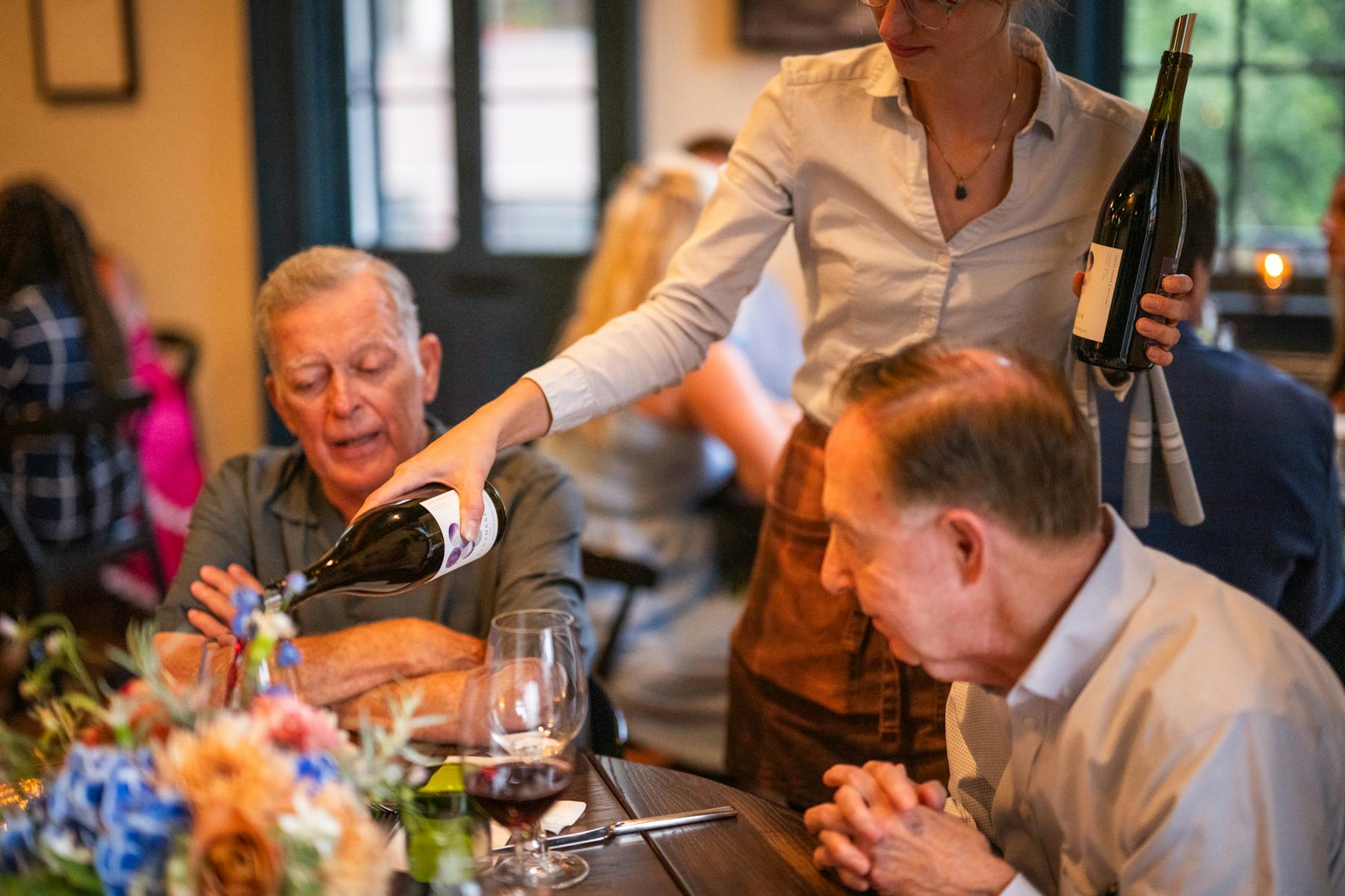 a group of people sitting at a table with wine glasses