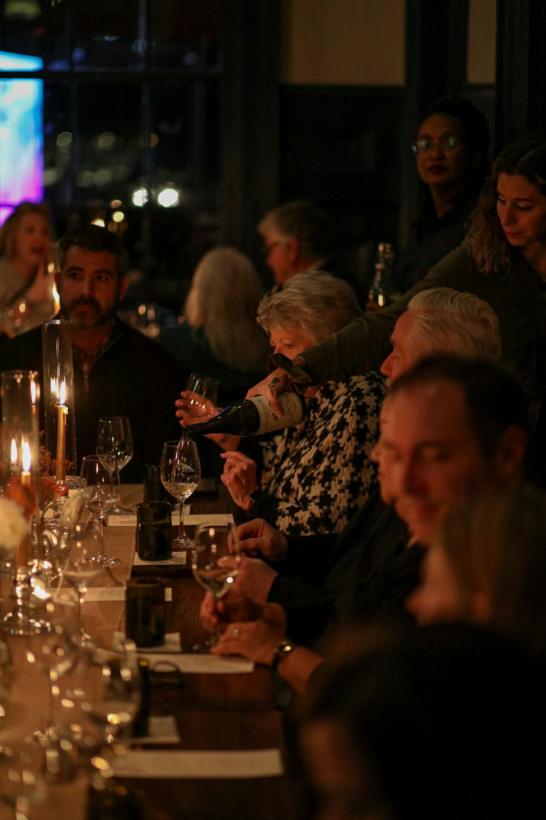 a group of people sitting at a table with wine glasses