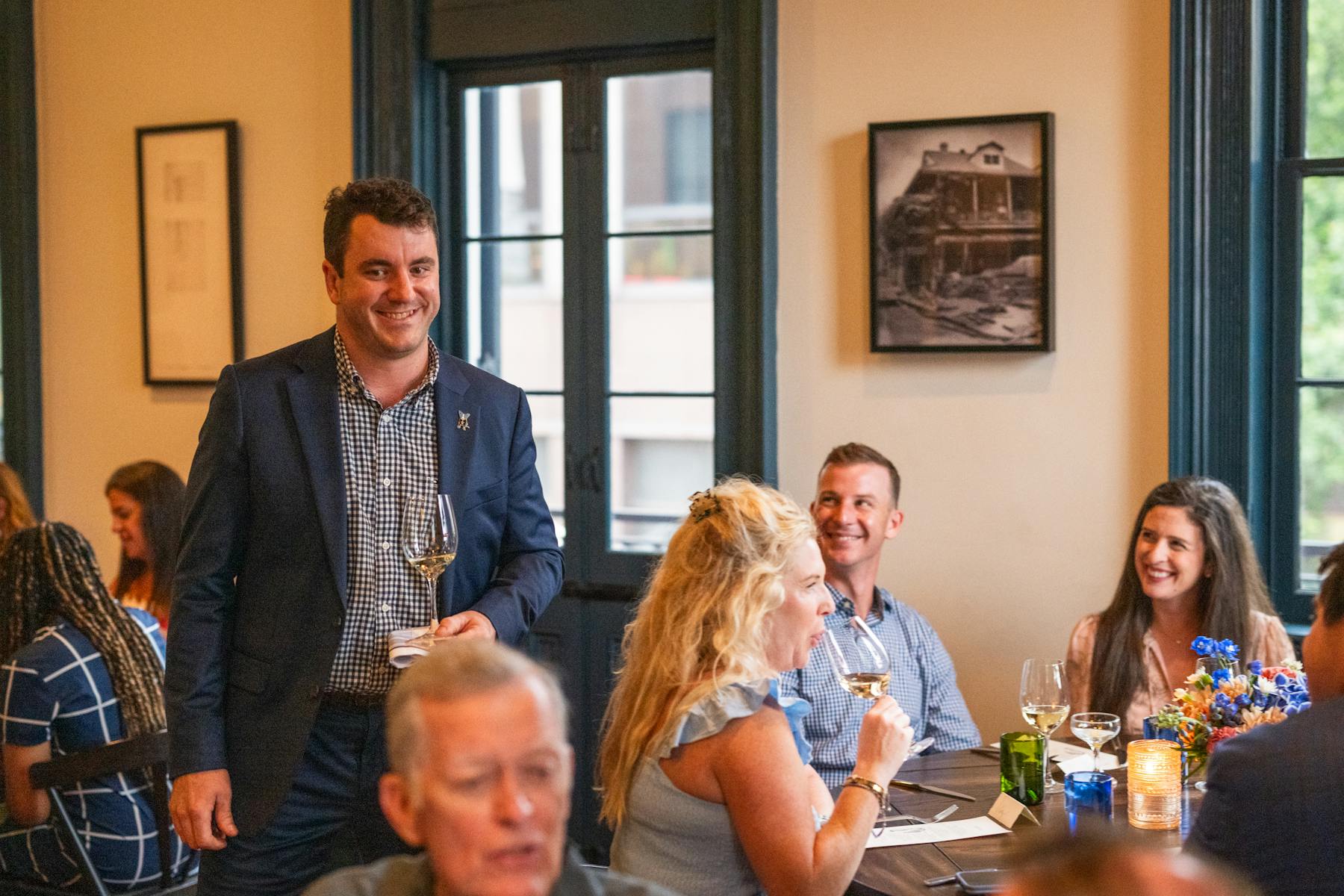 a group of people sitting at a table with a cake