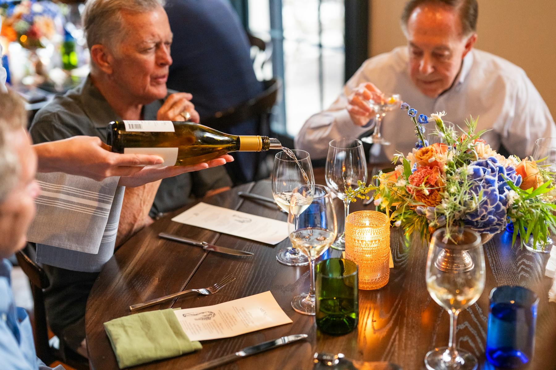 a group of people sitting at a table with wine glasses