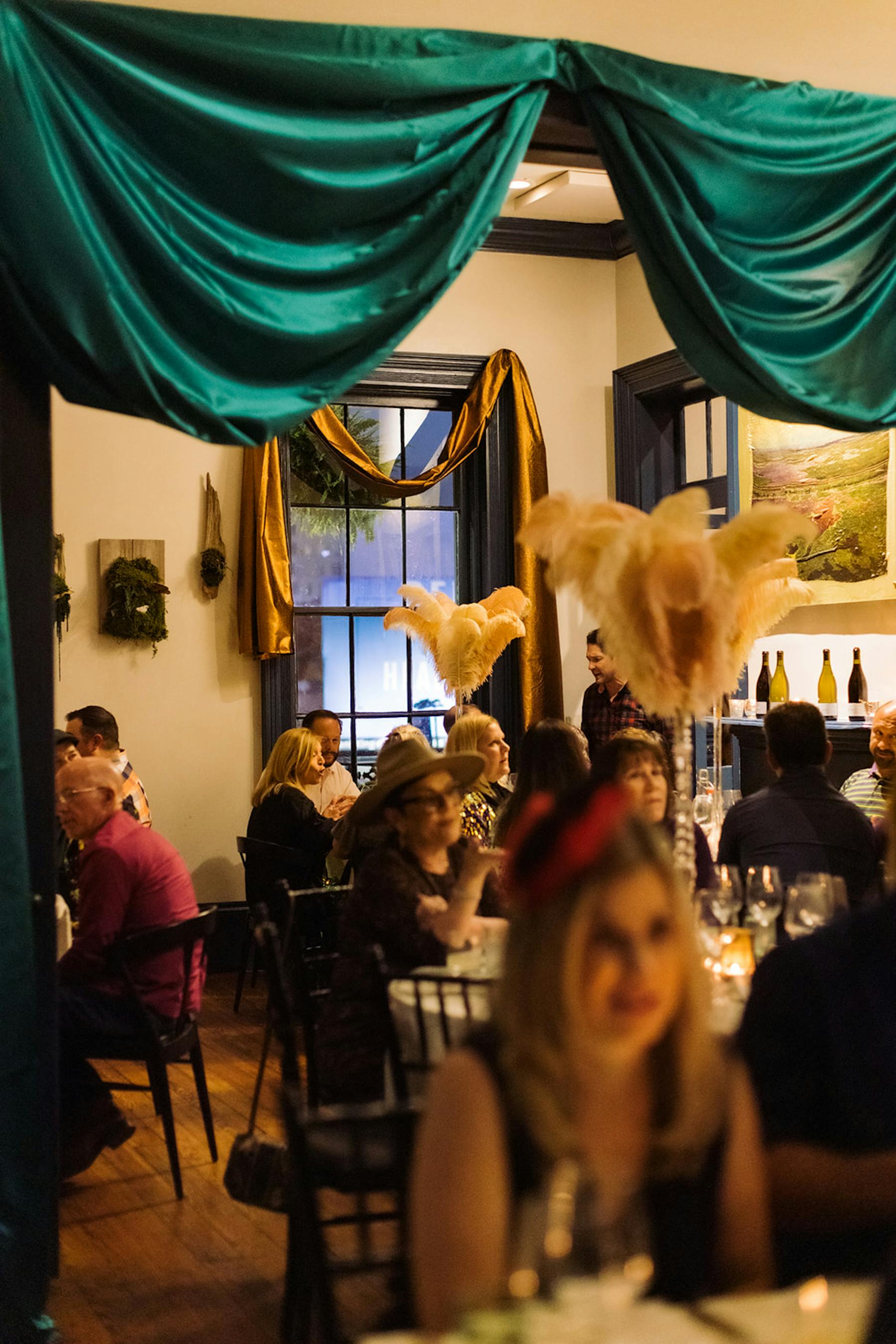 A spacious room filled with people seated at tables, engaged in conversation and activities