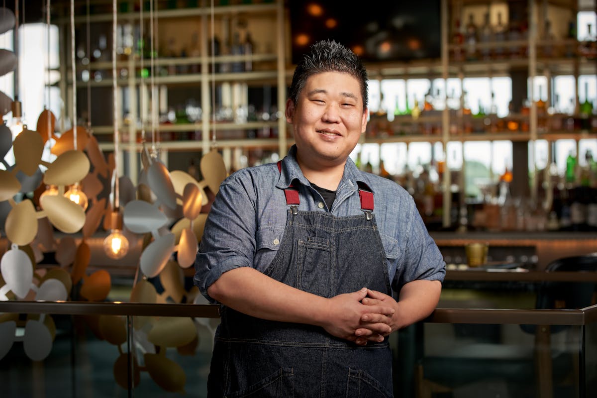 a smiling man standing in front of a store