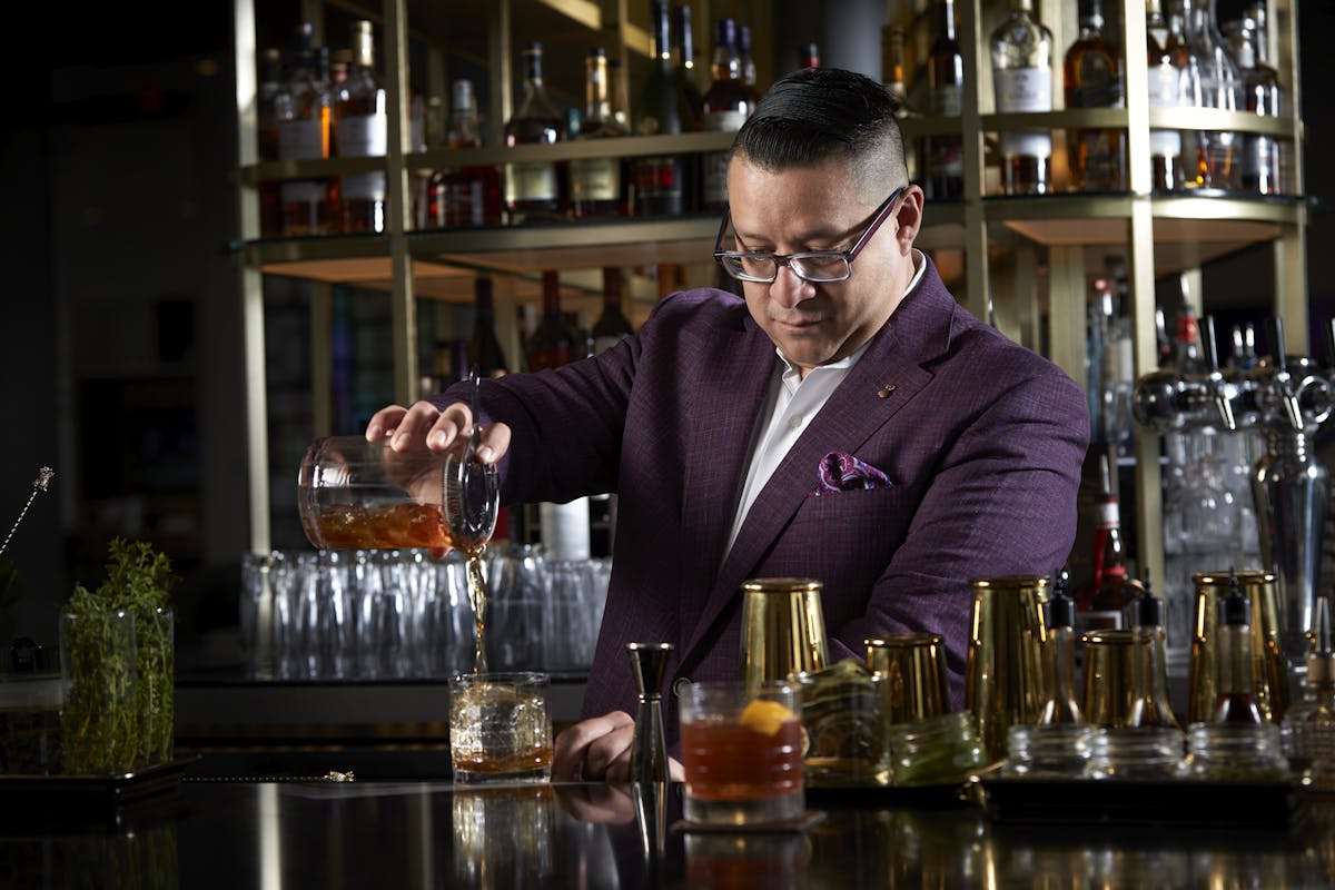 a man sitting at a table with wine glasses