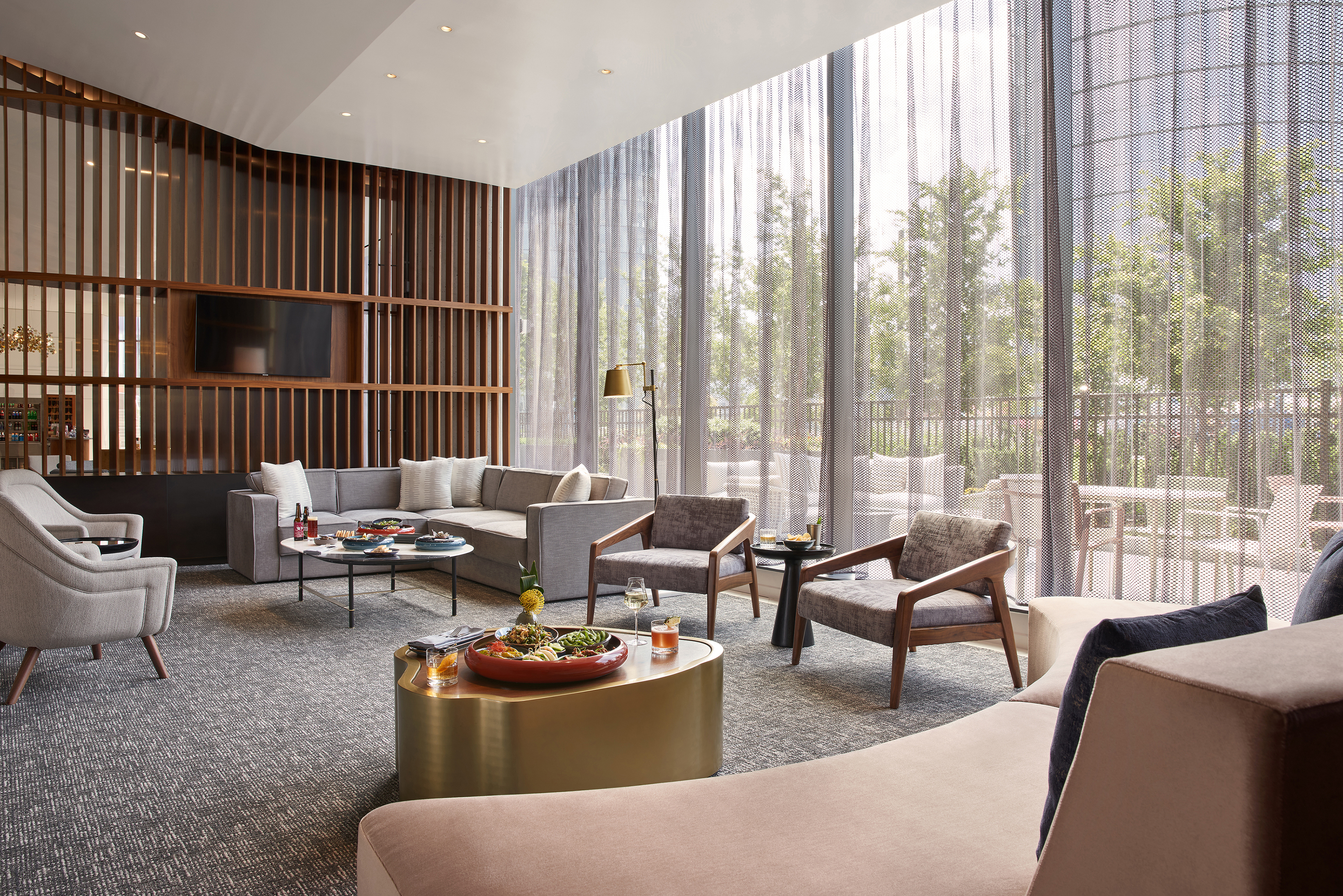 A Semi-Private Living Room Style Space With Lounge Furniture, Food, Cocktails, Wine And A Large Window