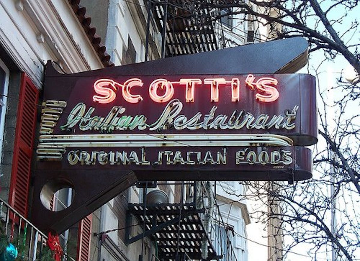 a sign hanging off the side of a building