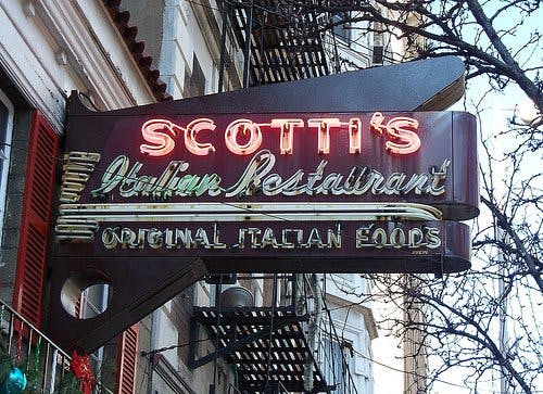 a sign hanging off the side of a building