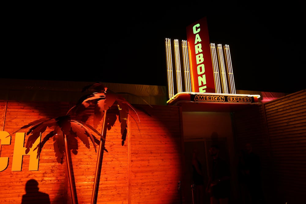 a vase of flowers sits in front of a sunset