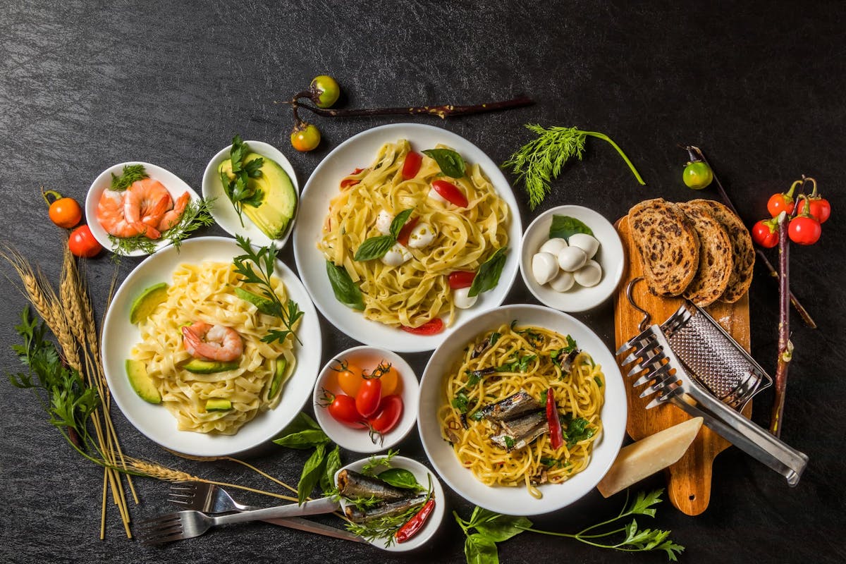 A table full of pasta and italian food.