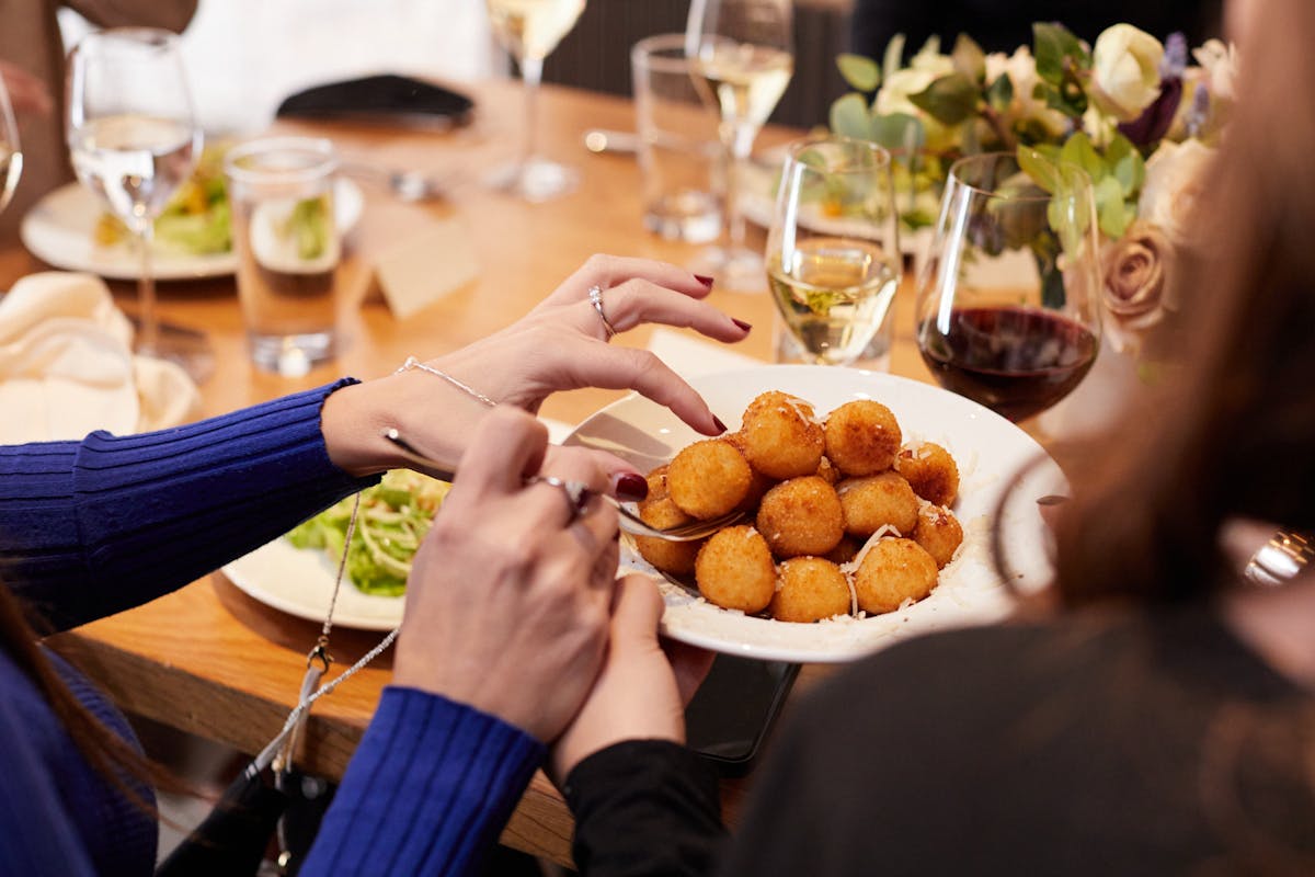 a group of people sitting at a table with a plate of food