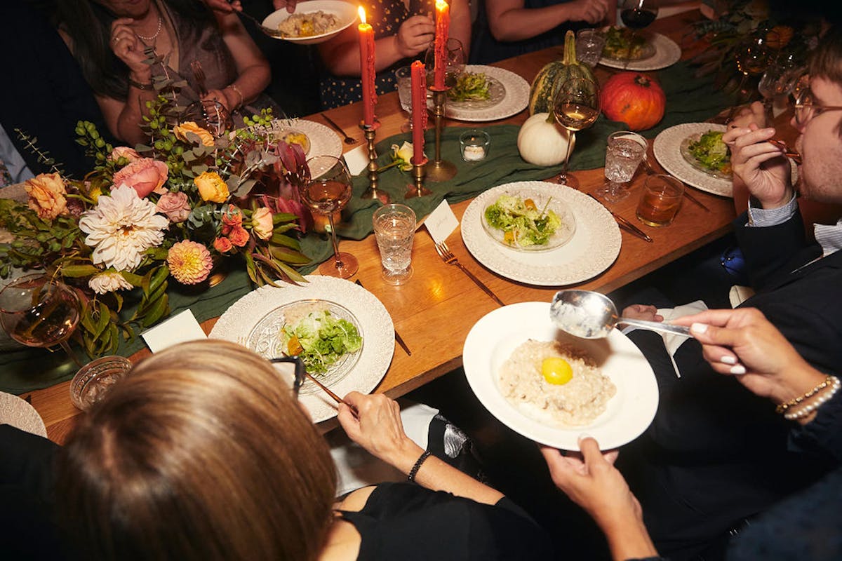 a group of people sitting at a table with a plate of food
