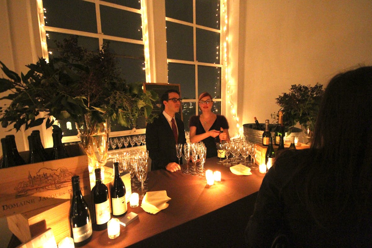 a man sitting at a table with wine glasses