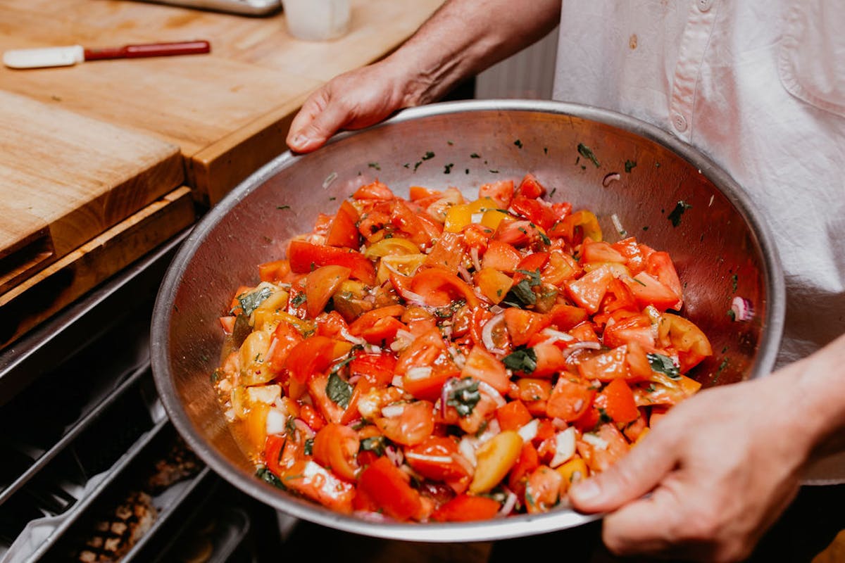 a person holding a pan of food on a table