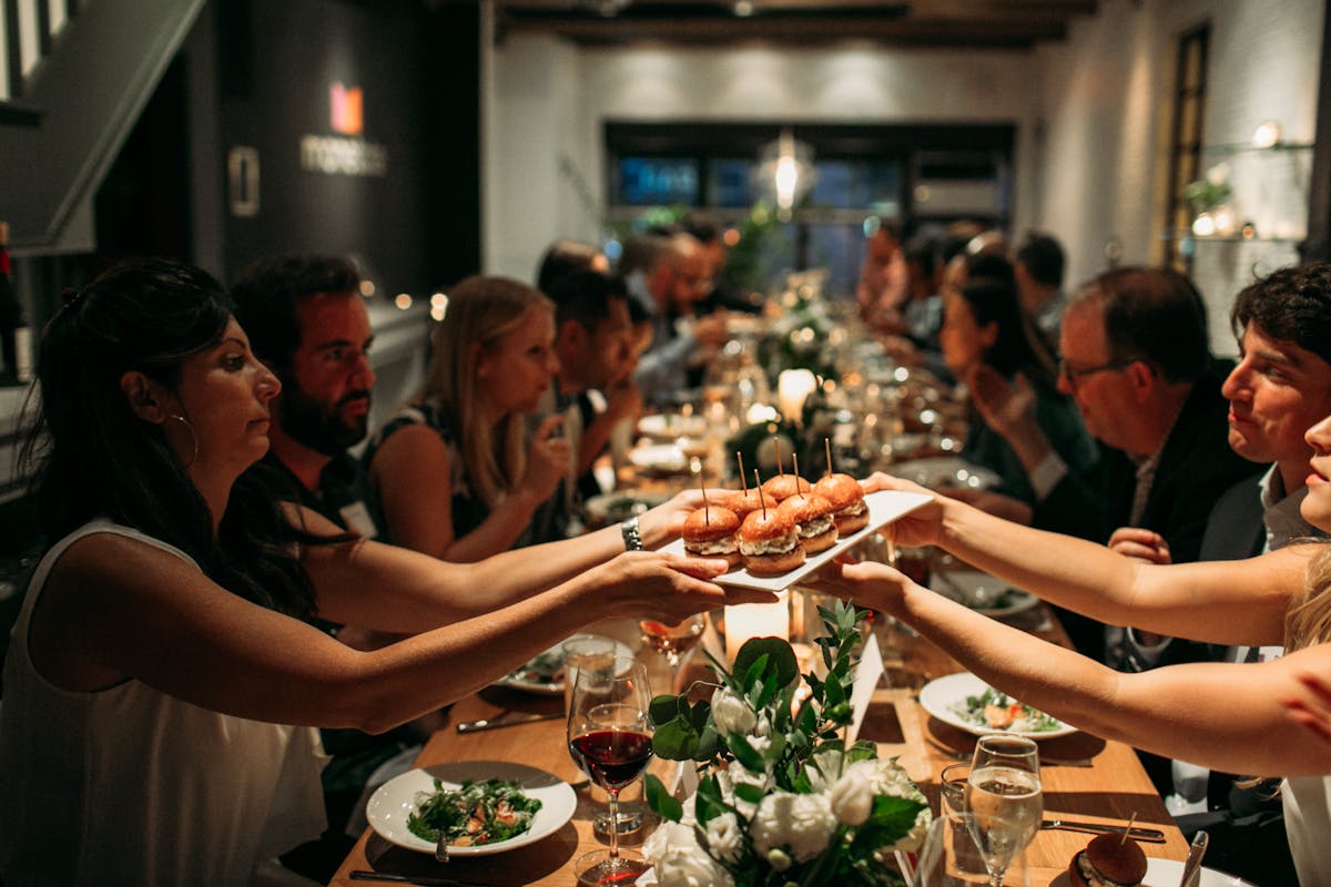 a group of people sitting at a table eating food