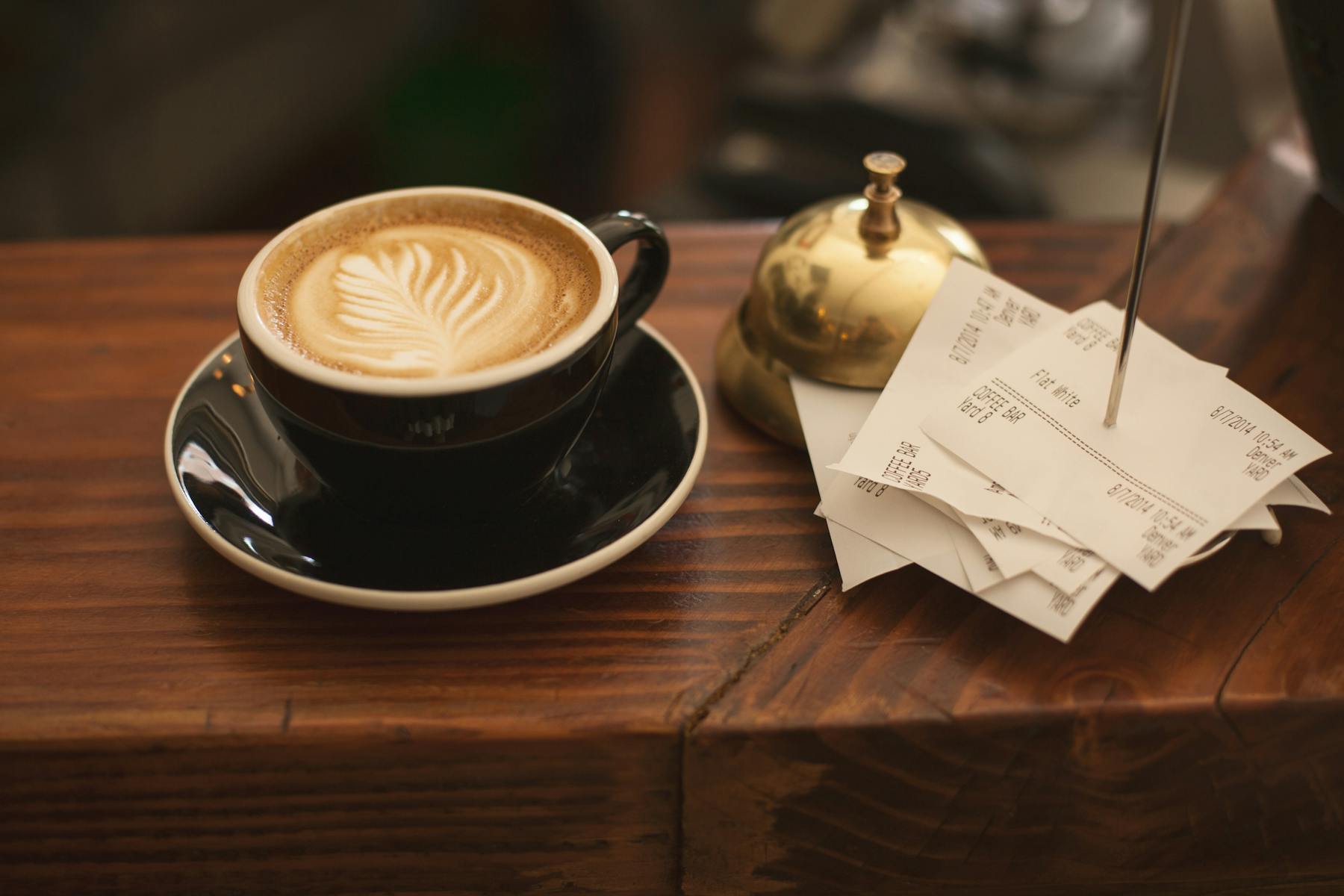a cup of coffee sitting on top of a wooden table