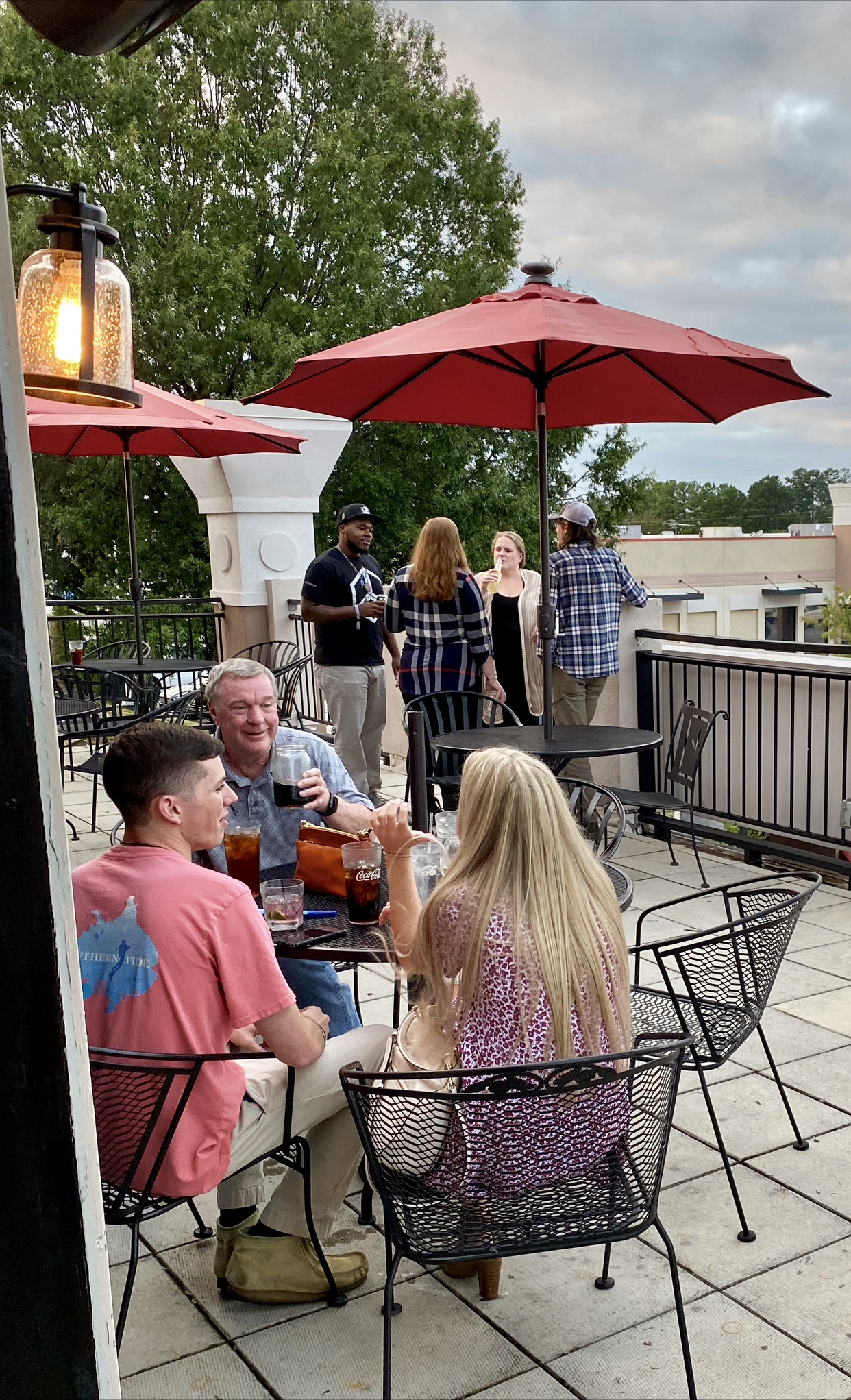 a group of people sitting in a chair with an umbrella