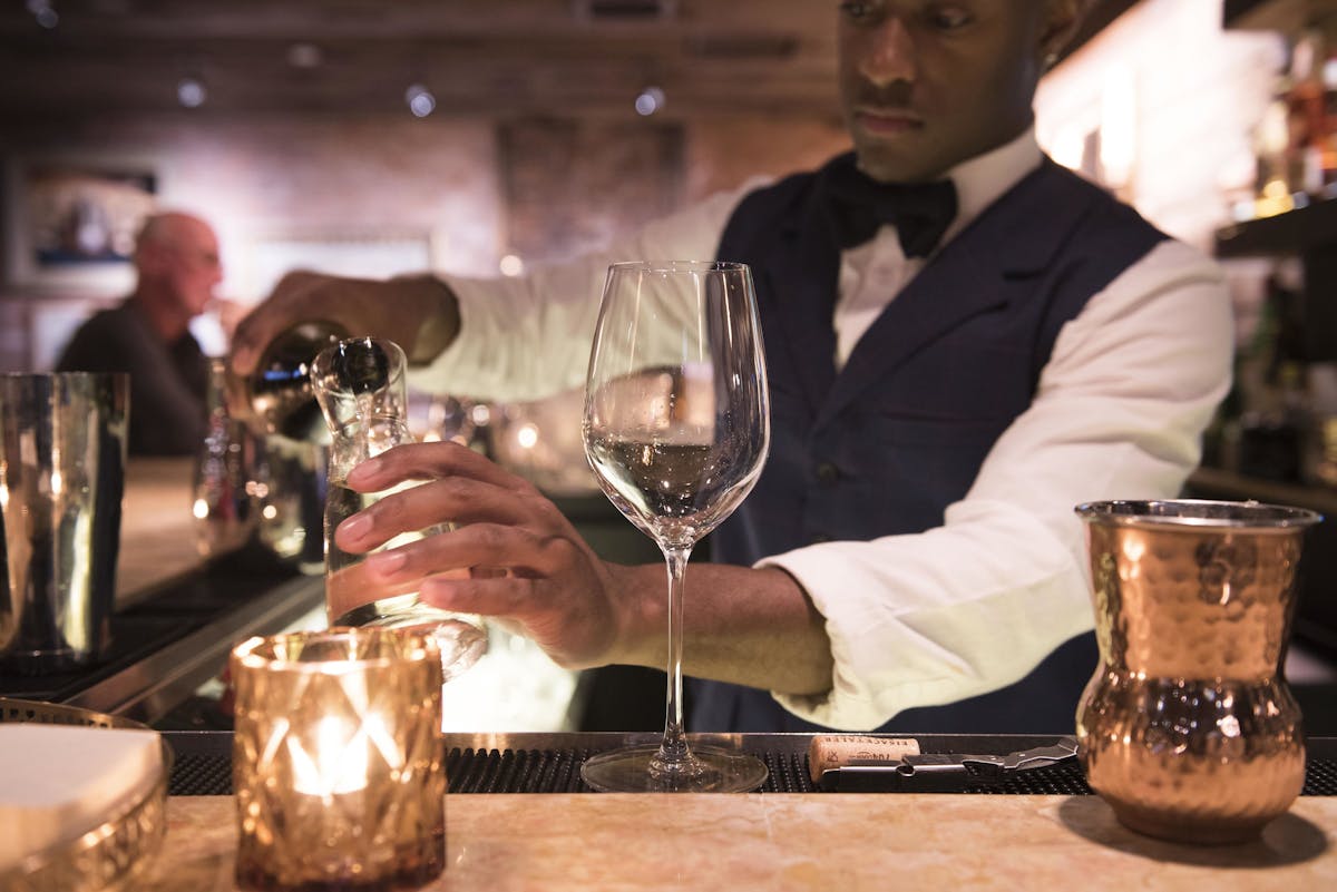 a person sitting at a table with wine glasses