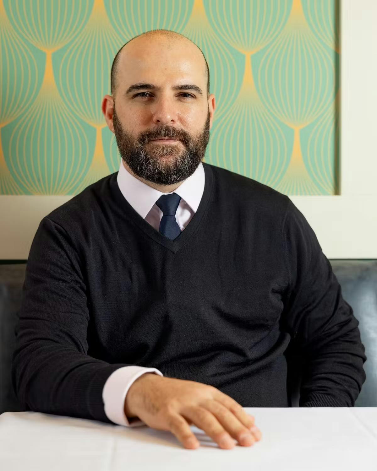 a man sitting at a table posing for the camera