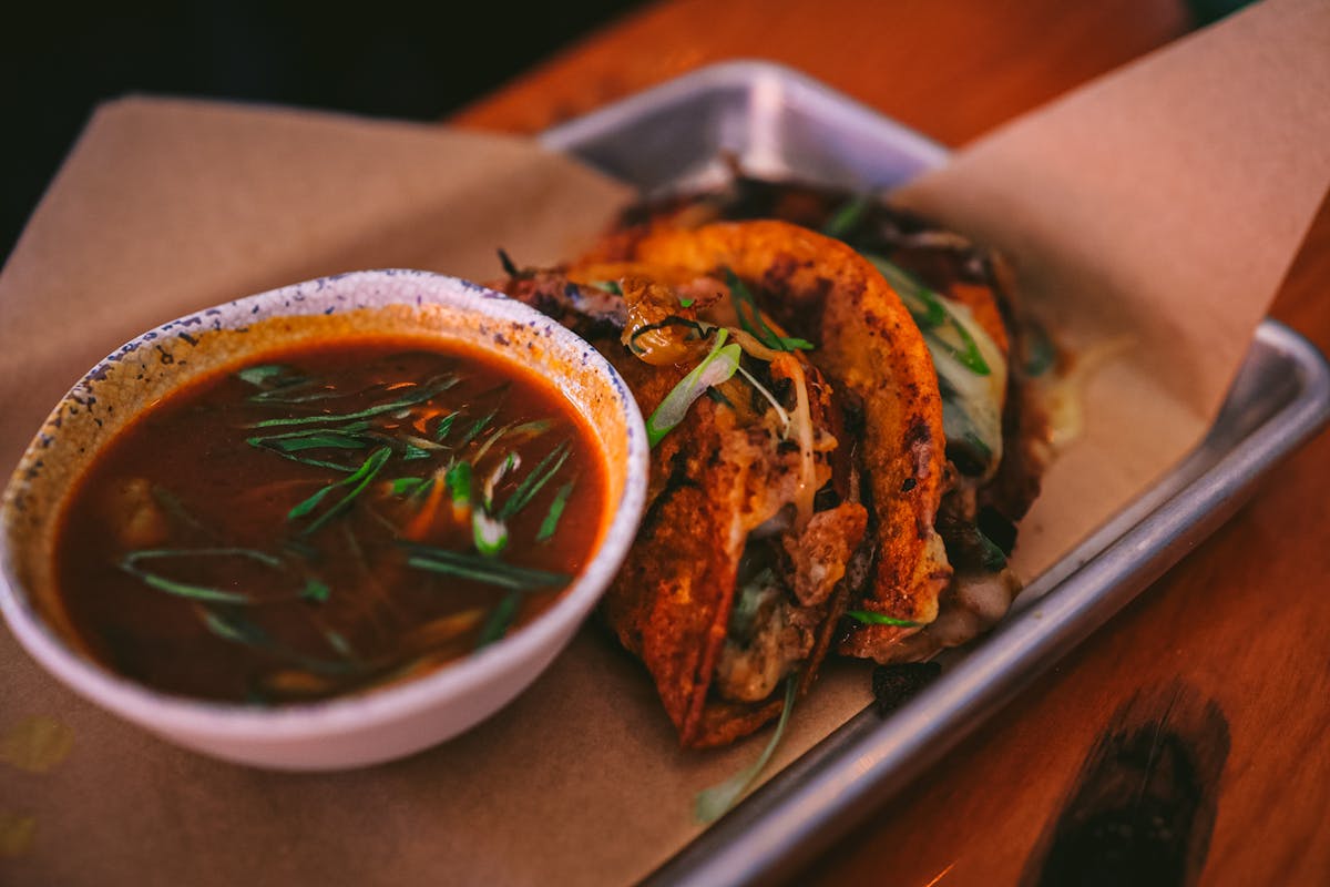 a bowl of food sitting on top of a wooden table