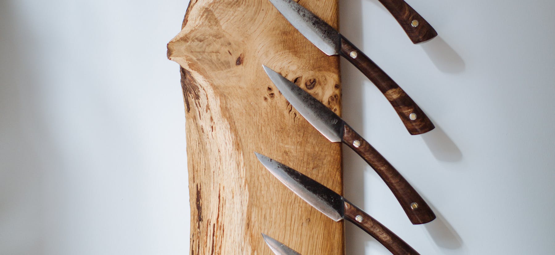 a pair of metal scissors sitting on top of a wooden cutting board
