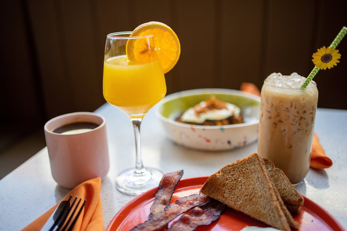 a plate of food and a glass of orange juice