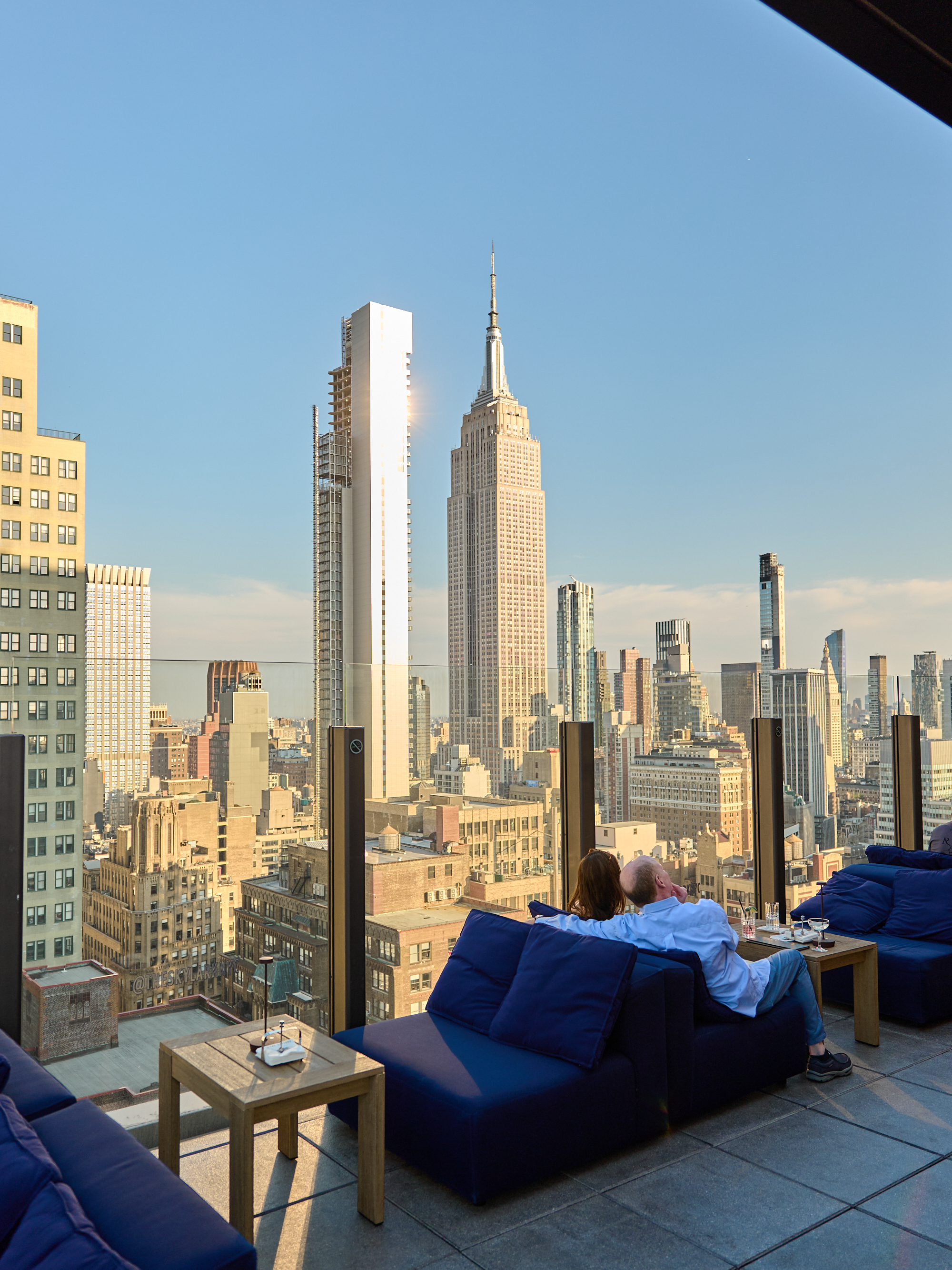 a couple sitting on a couch overlooking a city
