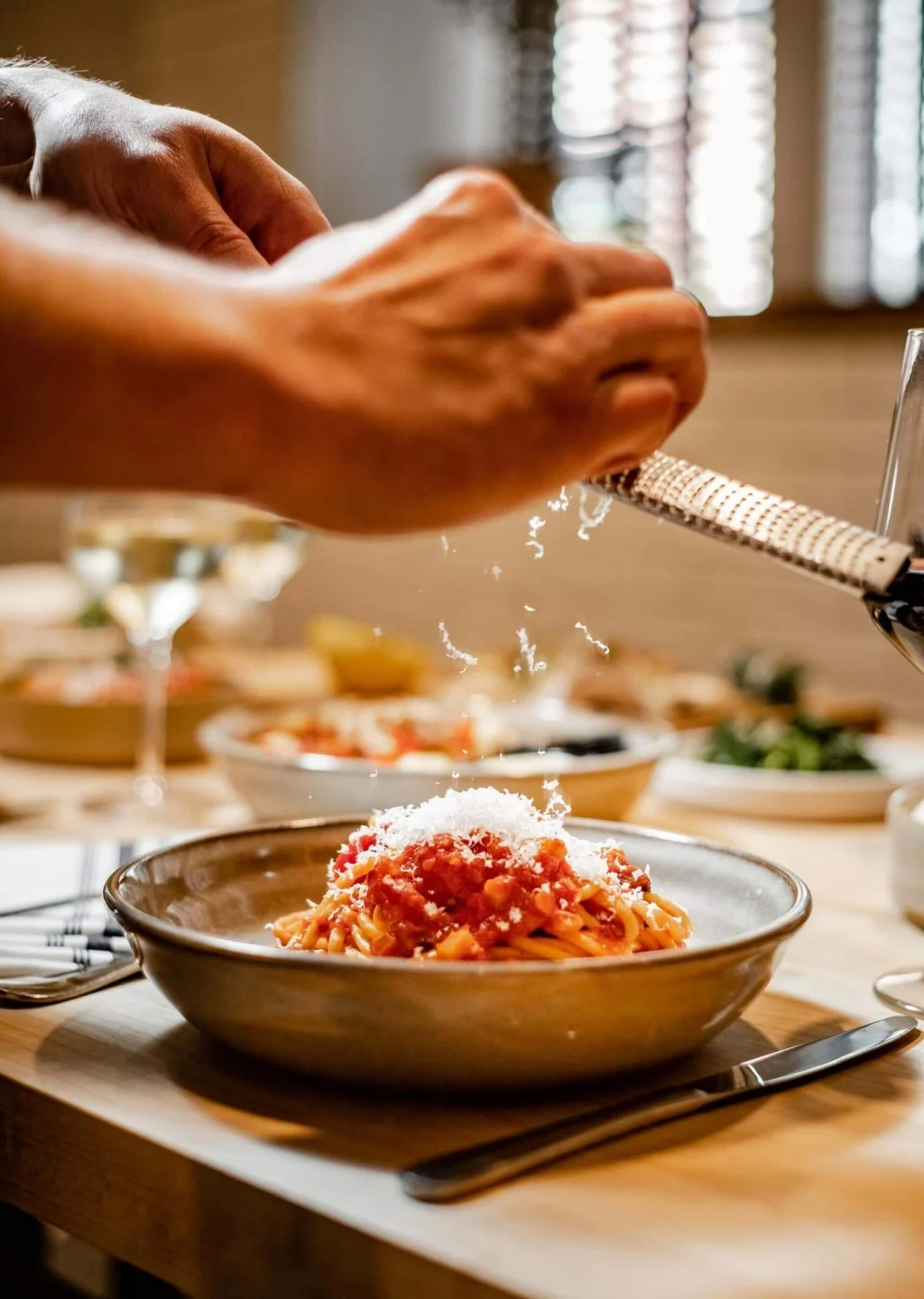 a person grating a plate of pasta