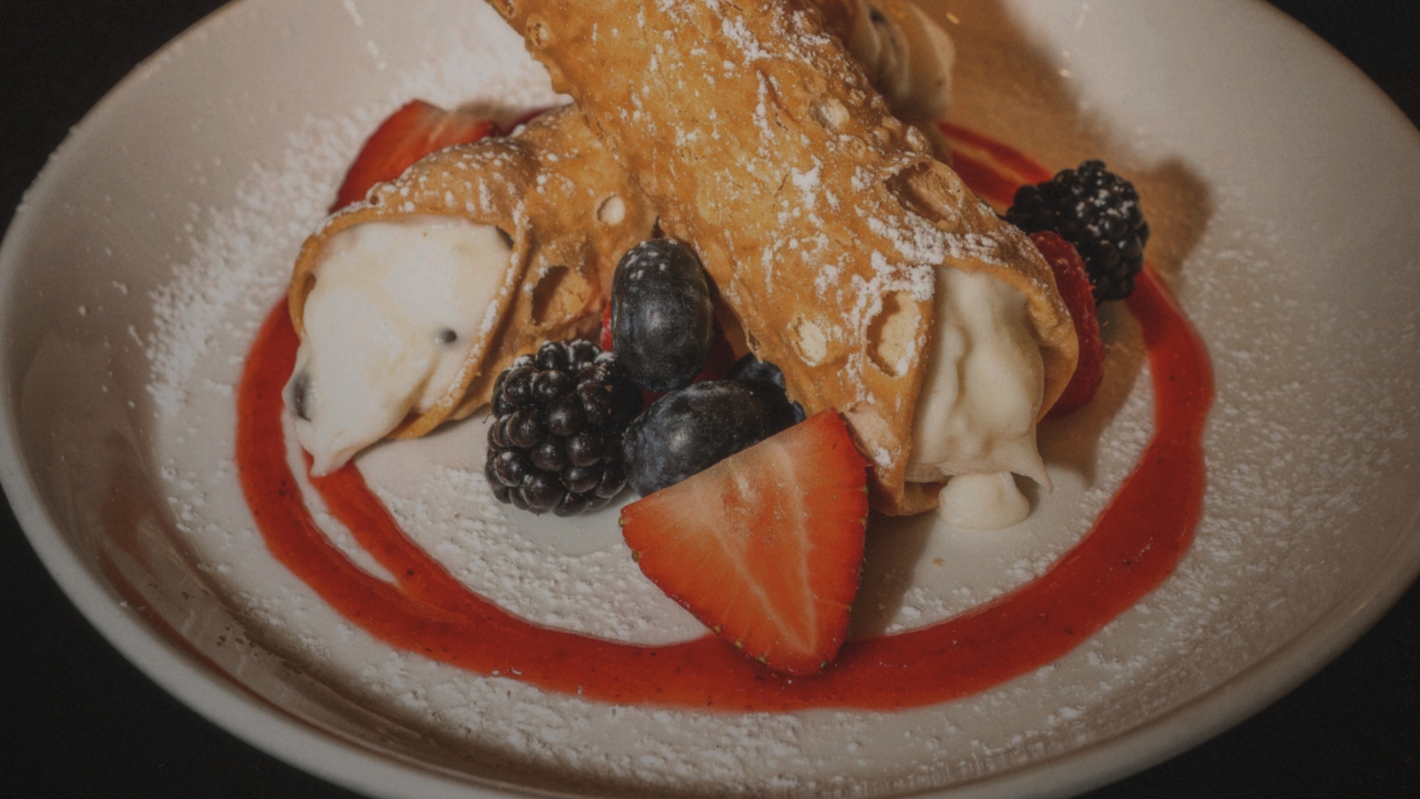 Cannoli with fresh berries and strawberry sauce.