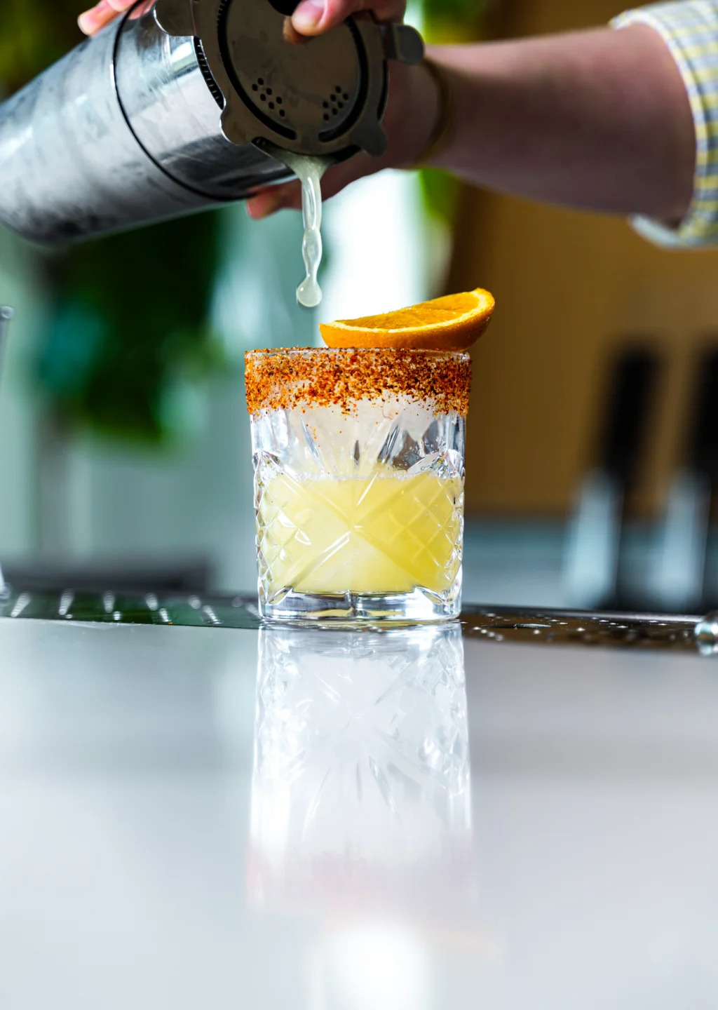 a person pouring a drink into a glass