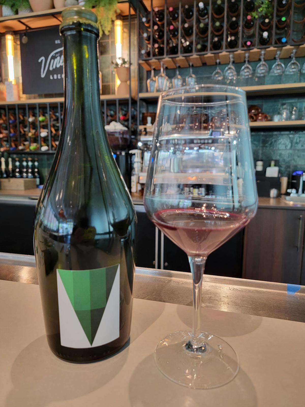 a bottle and glass of stella crinita petit verdot at a wine bar in midtown atlanta