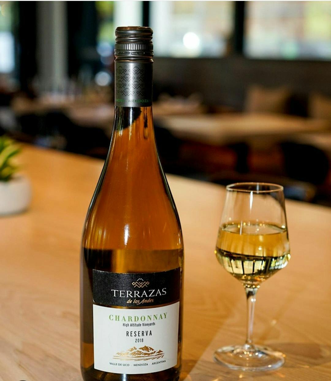 a close up of a bottle of chardonnay wine on a table