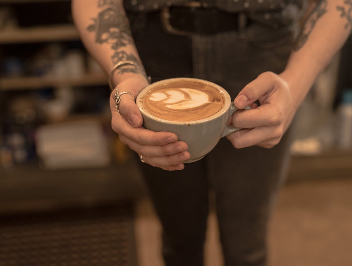 a hand holding a cup of coffee