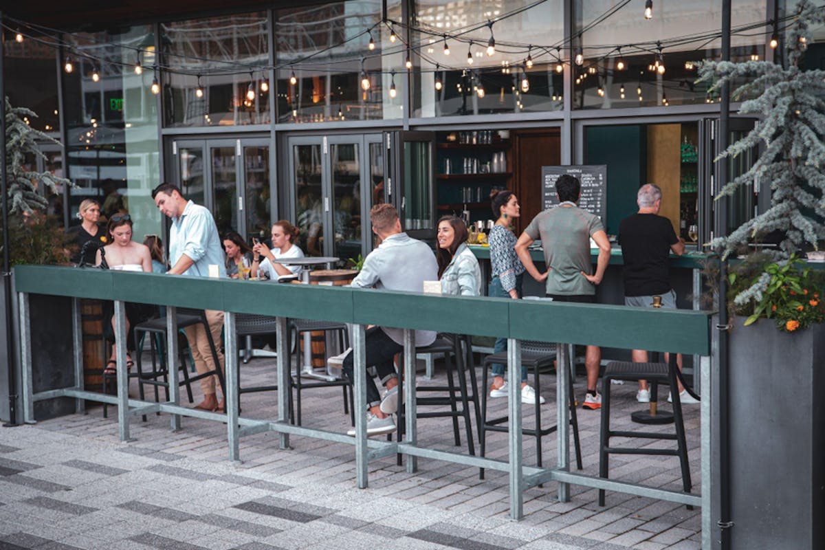 a group of people sitting at a table in front of a building