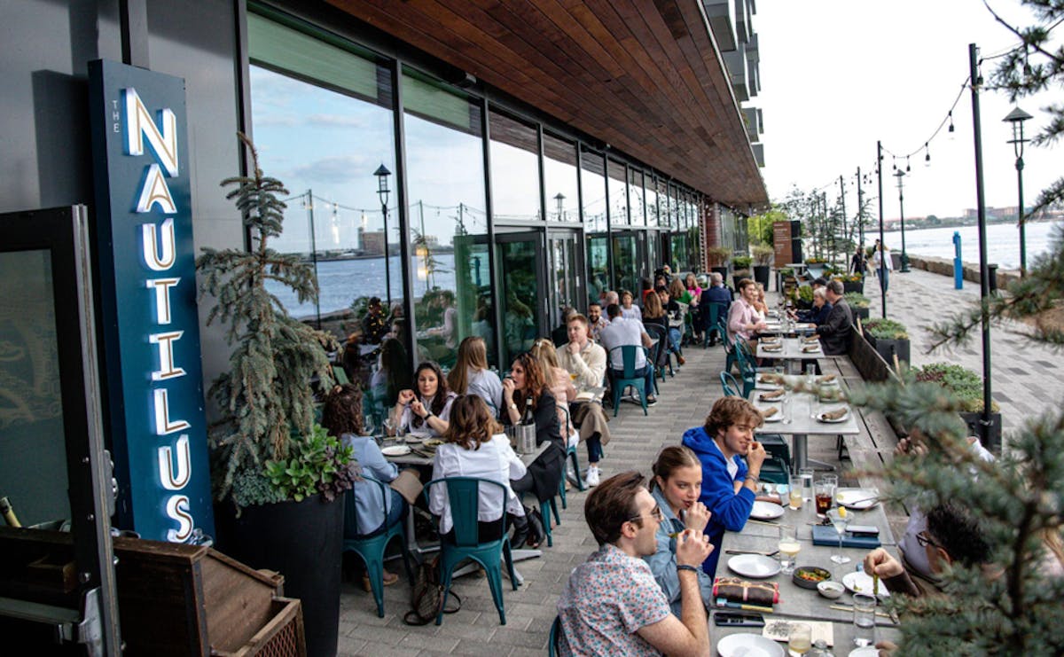 a group of people sitting at a table in front of a building