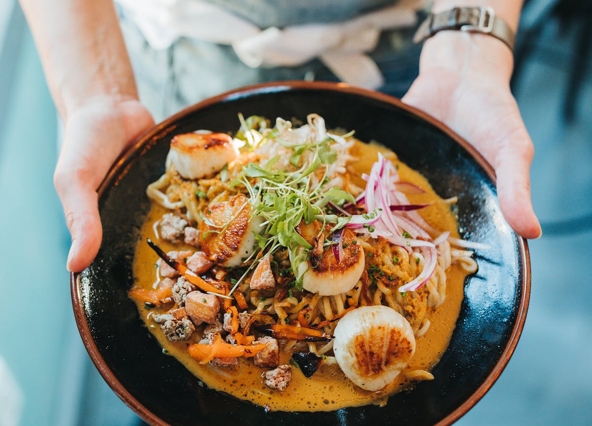 a person holding a pan of food