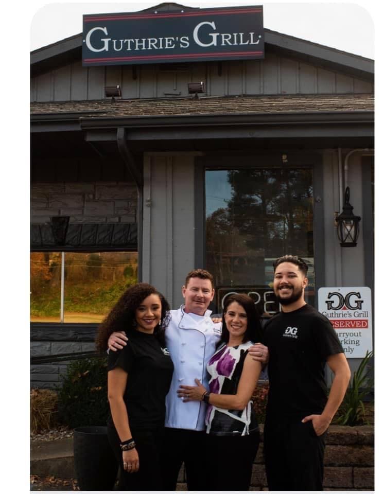 a group of people posing for a photo in front of a building