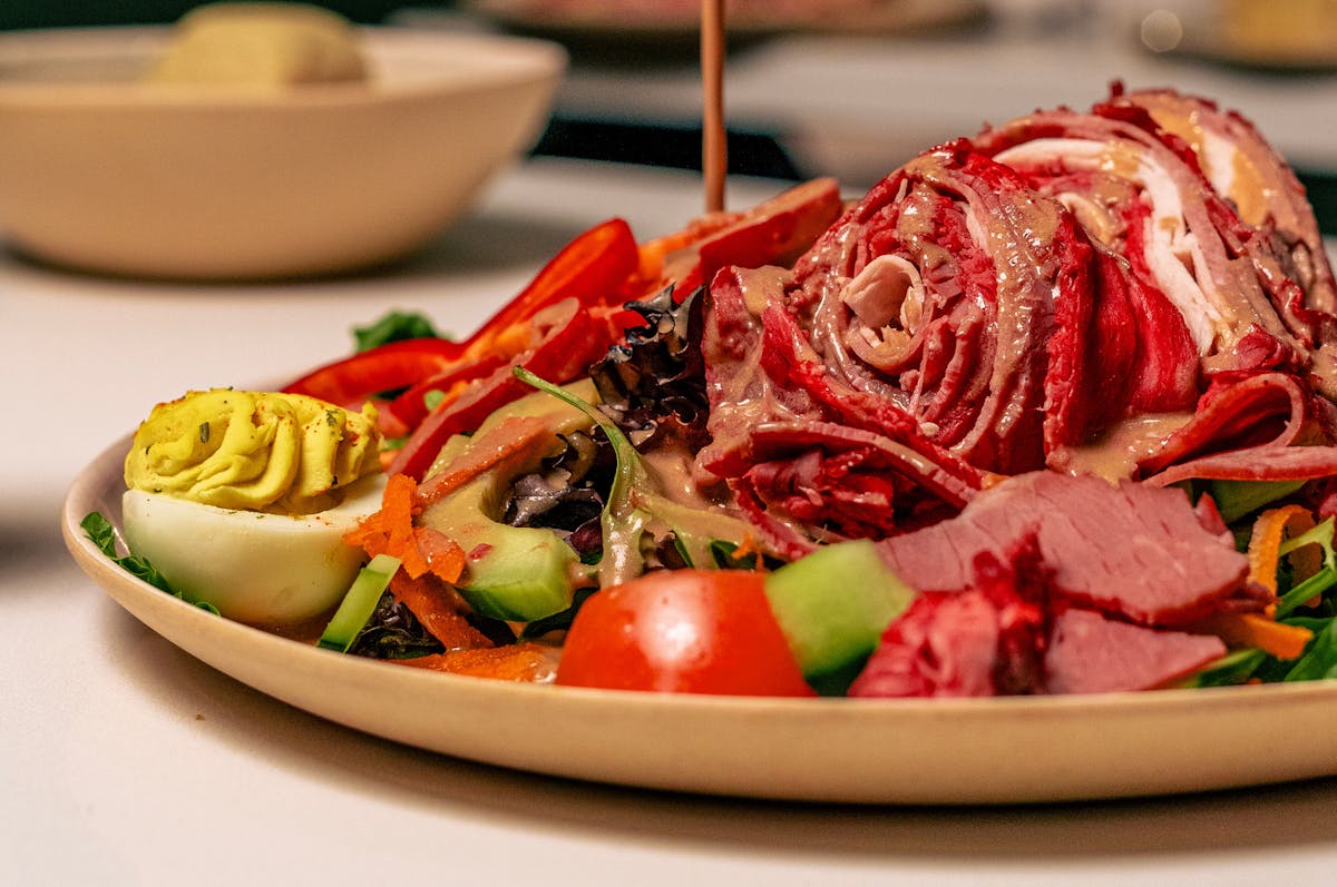 A plate filled with a serving of meat alongside a colorful assortment of fresh vegetables.