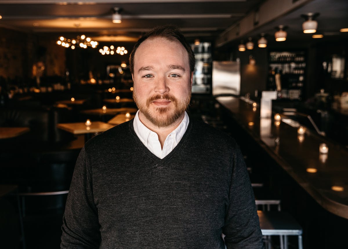 a man standing in front of a restaurant