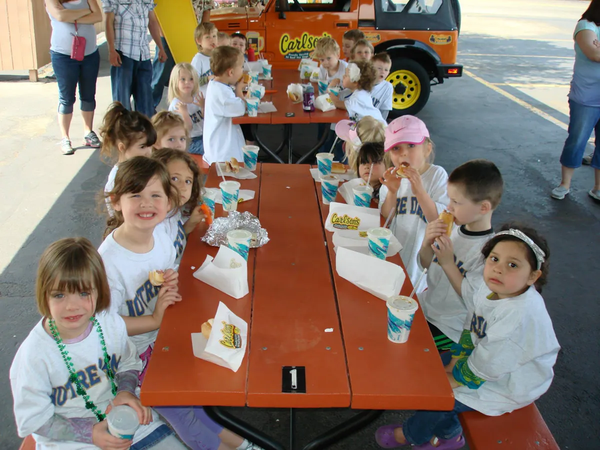 a group of young children sitting on picnic chairs